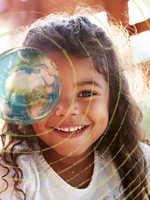 Girl looks through transparent globe, she is smiling.